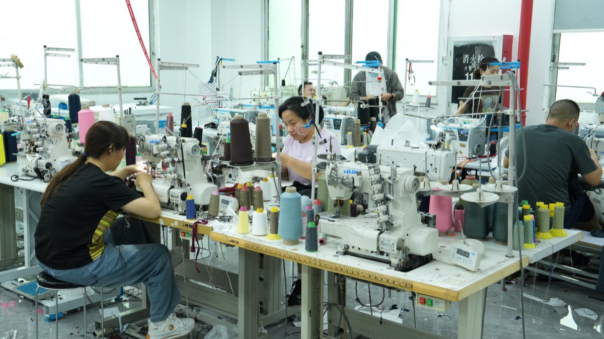 Sample room production floor with sewing machines and operators developing activewear styles